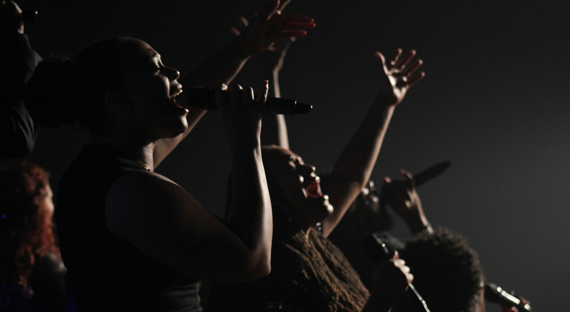 Choir singing hands raised 72px