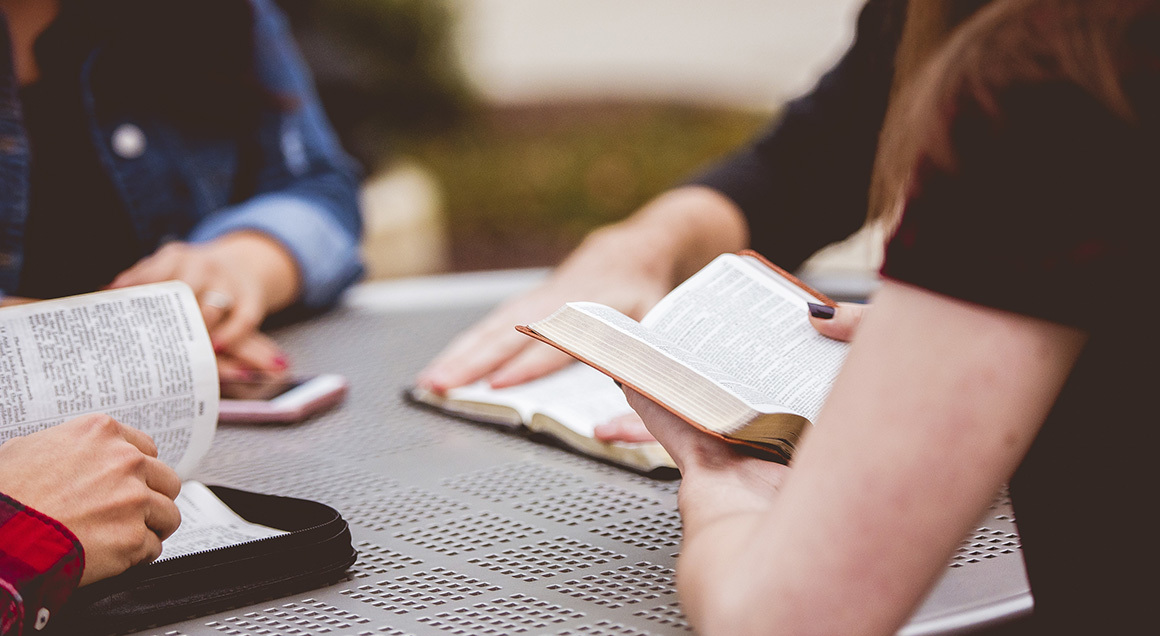 Stock Group reading Bibles at outside table